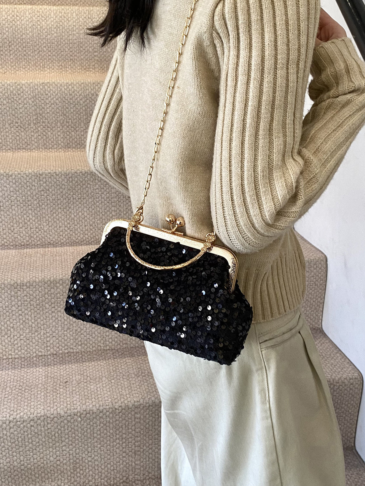 Pochette da sera ricoperta di paillettes brillanti con manico dorato