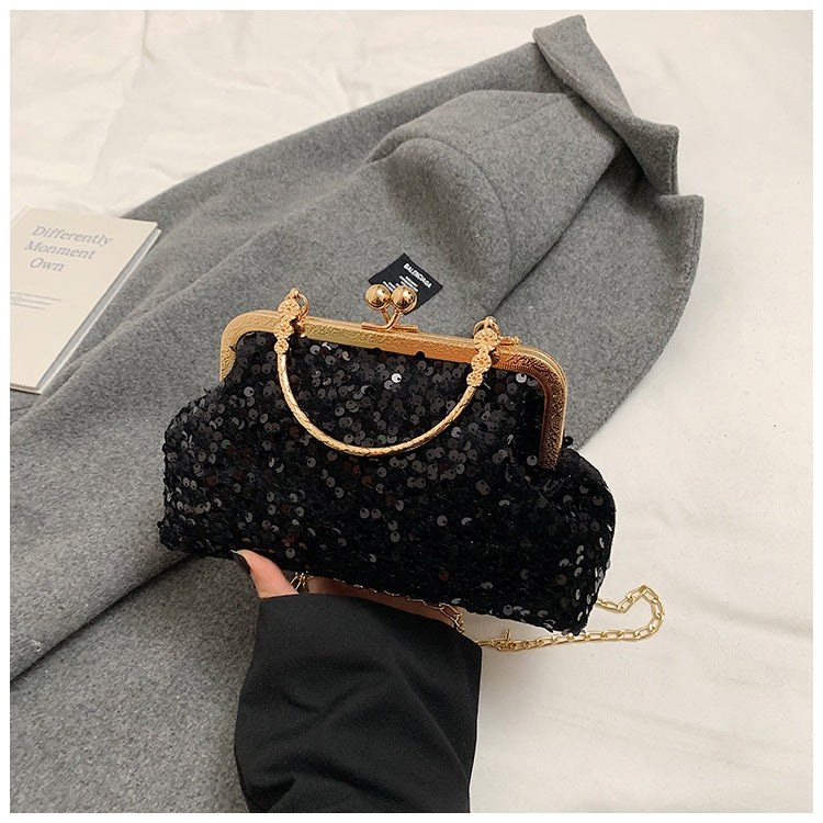 Pochette da sera ricoperta di paillettes brillanti con manico dorato