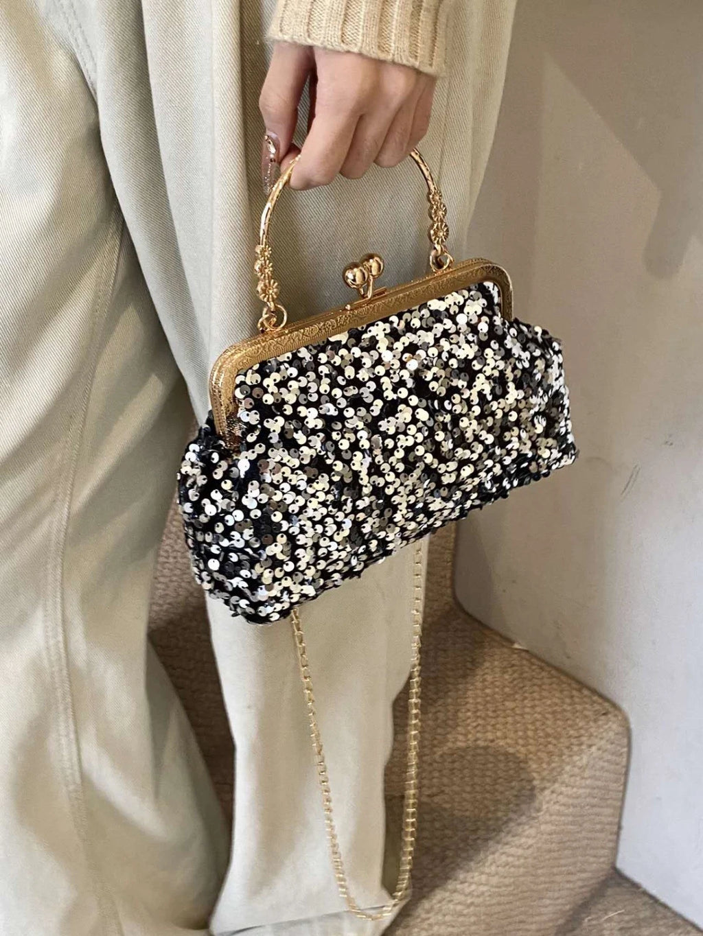 Pochette da sera ricoperta di paillettes brillanti con manico dorato