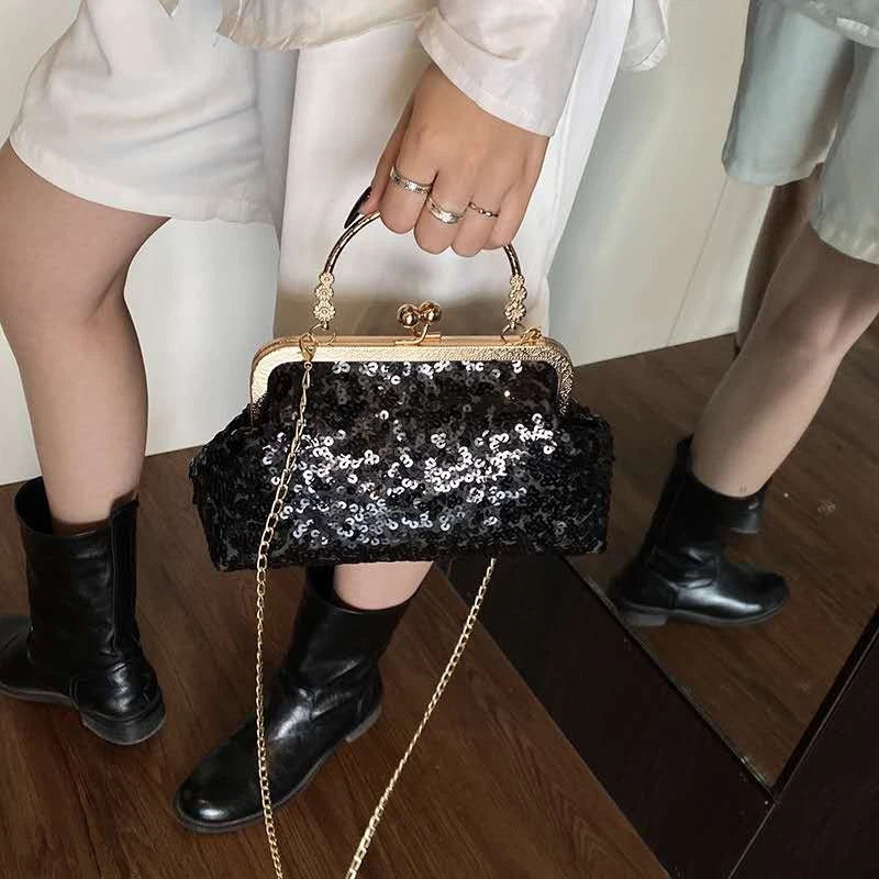 Pochette da sera ricoperta di paillettes brillanti con manico dorato