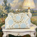 Hand-embroidered clutch bag with floral motifs in light blue or pink