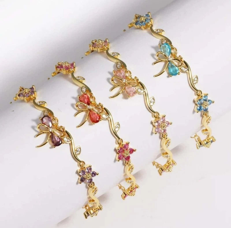 Bracciale regolabile con fiocco e fiore color oro e zirconi con cristalli