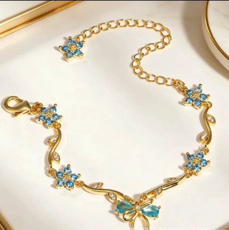 Bracciale regolabile con fiocco e fiore color oro e zirconi con cristalli