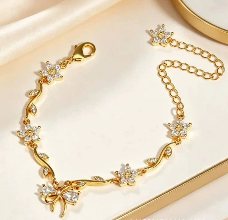 Bracciale regolabile con fiocco e fiore color oro e zirconi con cristalli