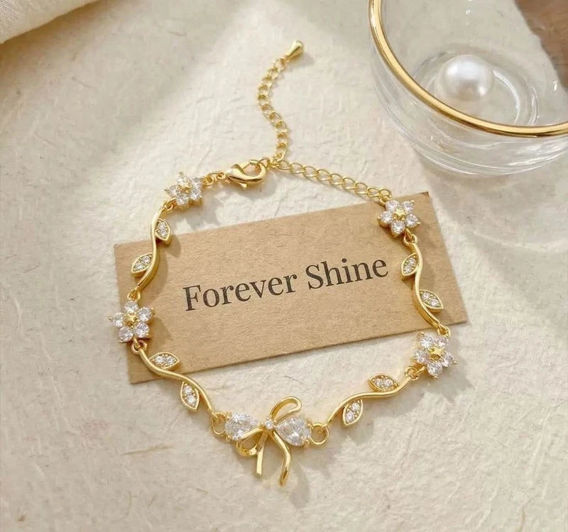 Bracciale regolabile con fiocco e fiore color oro e zirconi con cristalli