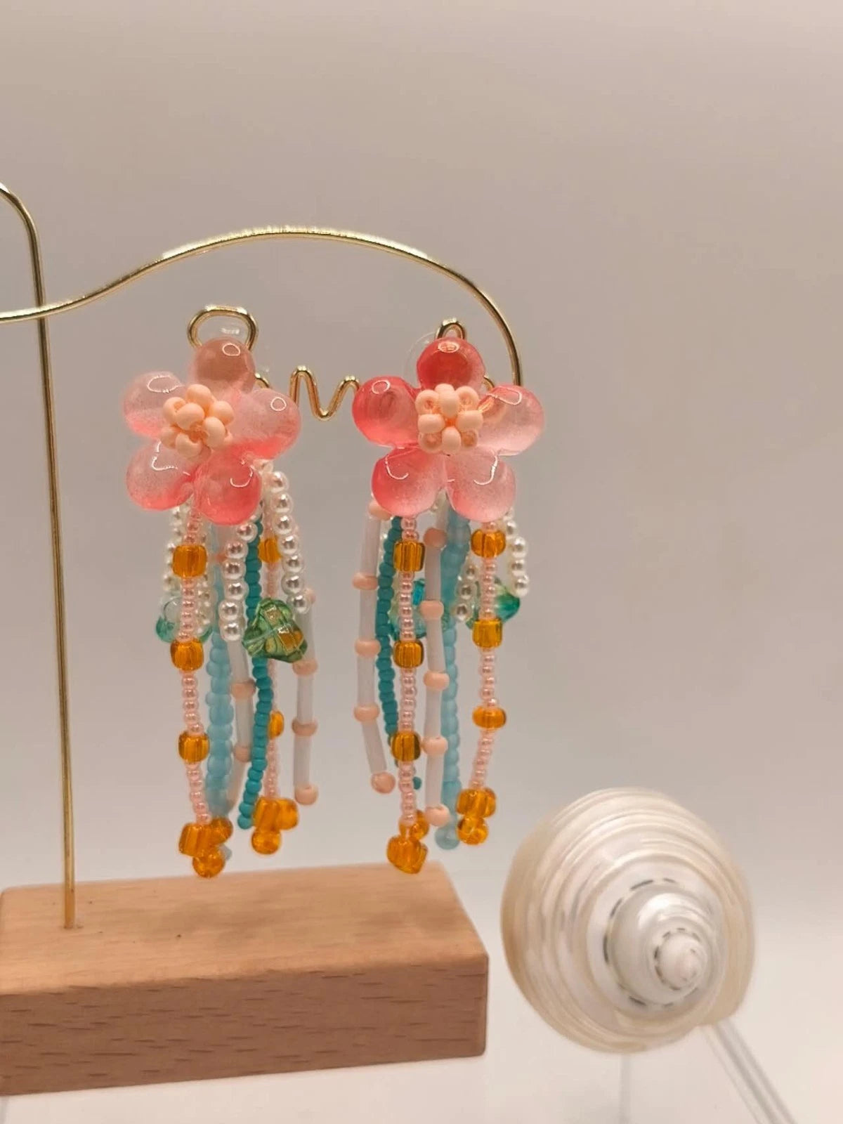 Handgefertigte Ohrringe mit Naturperlen und Kunstharz mit Blumenmotiven und Quasten