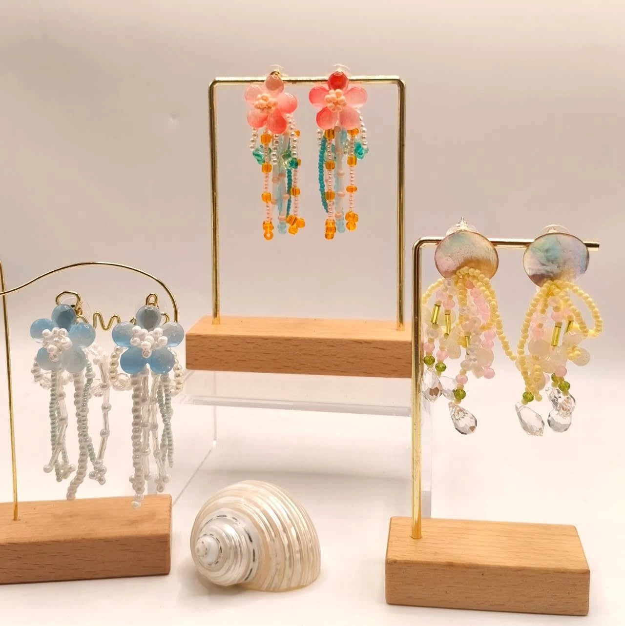 Handgefertigte Ohrringe mit Naturperlen und Kunstharz mit Blumenmotiven und Quasten
