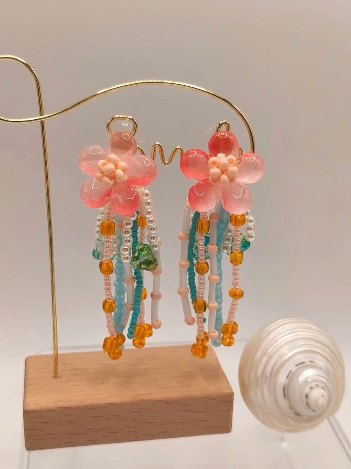 Handgefertigte Ohrringe mit Naturperlen und Kunstharz mit Blumenmotiven und Quasten