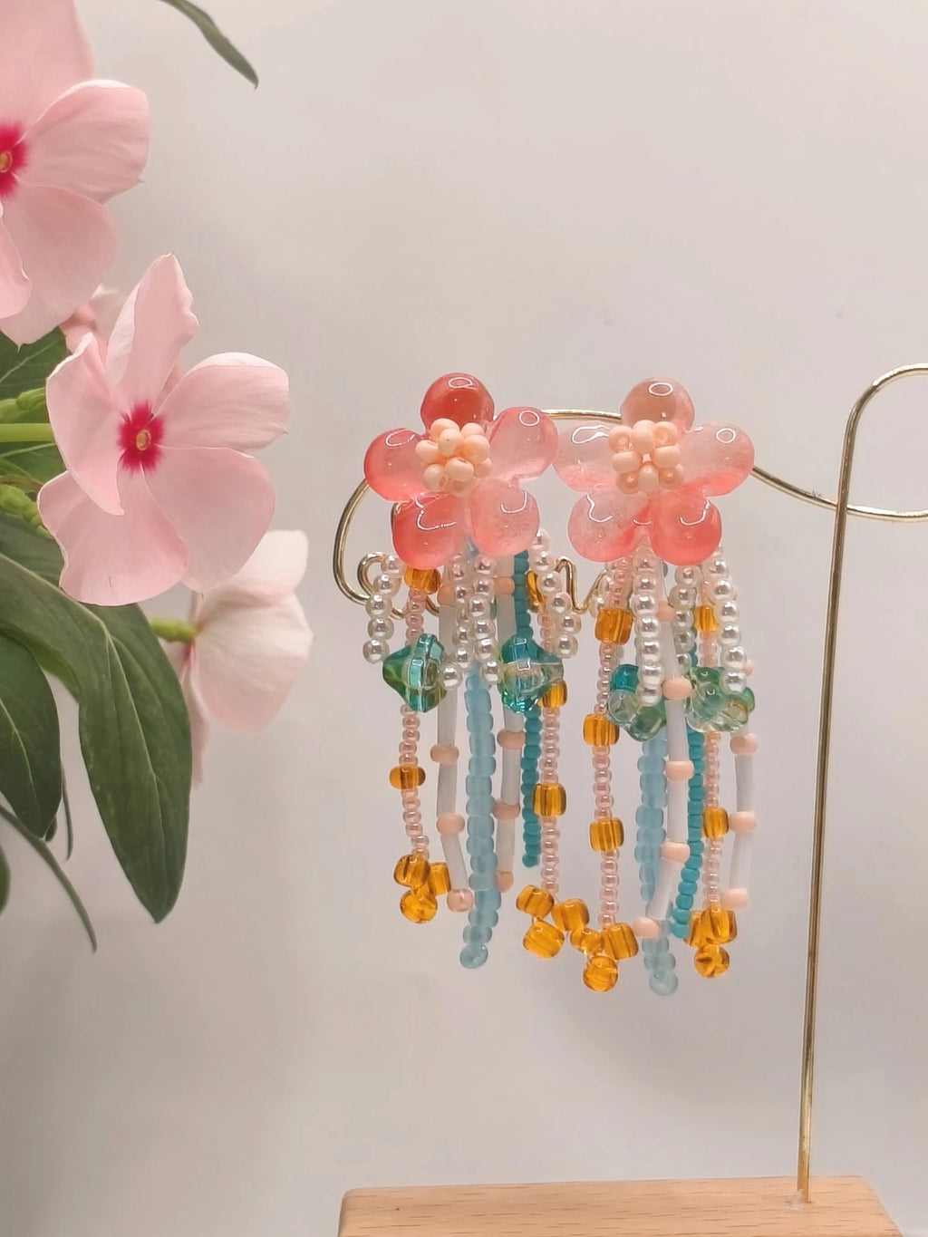 Handgefertigte Ohrringe mit Naturperlen und Kunstharz mit Blumenmotiven und Quasten