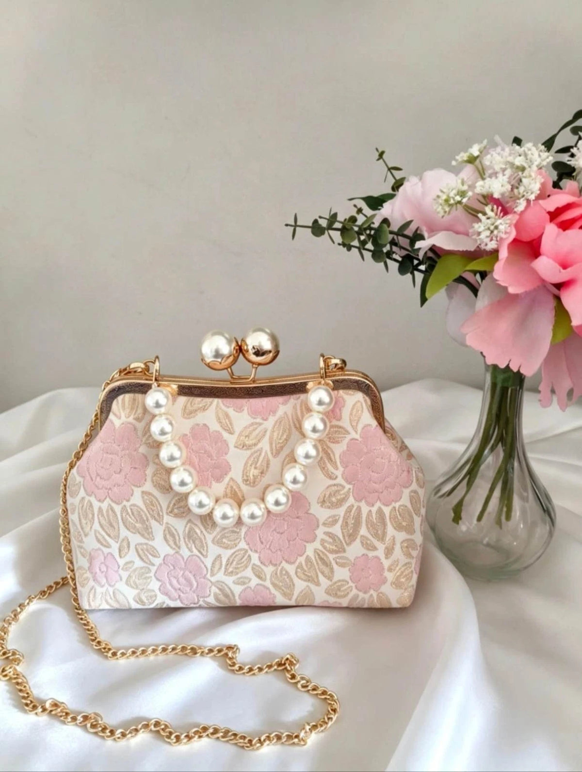 borsetta artigianale ricamata con motivi floreali rosa