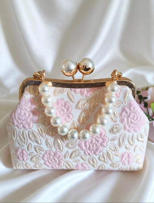 Hand-embroidered clutch bag with floral motifs in light blue or pink